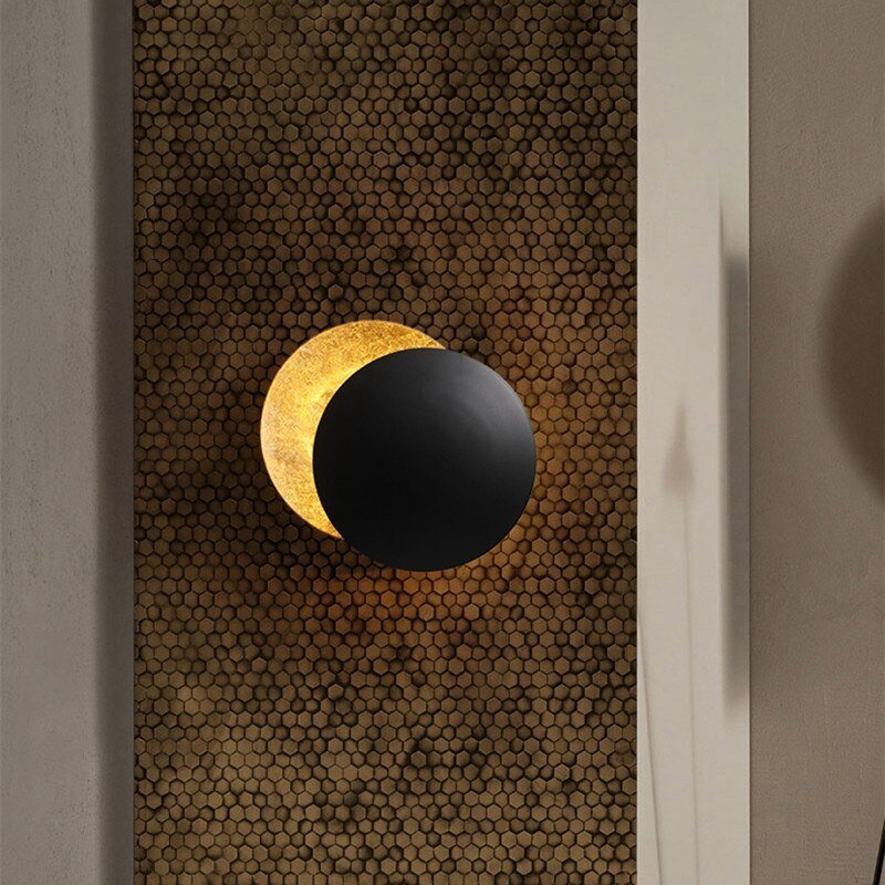 Aveloro Umbra LED-Wandleuchte in Gold und Schwarz an Wabenwand